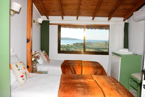 a room with two beds and a window at Teras Motel 12 Adults Only in Foça