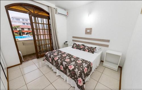 a bedroom with a bed and a door to a balcony at Acqua Floripa Morro das Pedras SC in Florianópolis