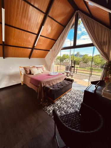 a bedroom with a bed and a couch and a window at Kabana Harmony in Aquidauana