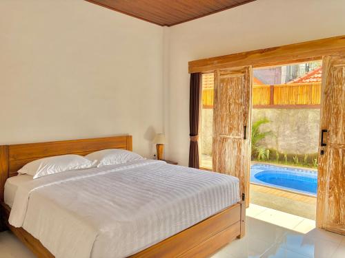 a bedroom with a bed and a window with a pool at Tanhana Seminyak in Kerobokan