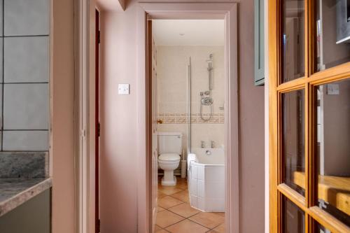 a bathroom with a white toilet and a tub at Gamul Place - Quiet City Centre in Chester