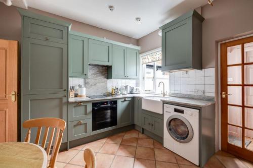 a kitchen with green cabinets and a dishwasher at Gamul Place - Quiet City Centre in Chester