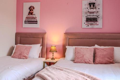 two beds in a room with pink walls at The Suite at O'Shea's in Killorglin