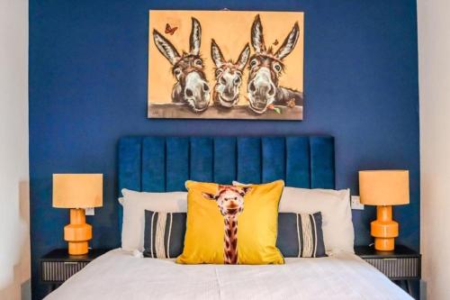a blue bedroom with a bed with a painting of deer at The Suite at O'Shea's in Killorglin
