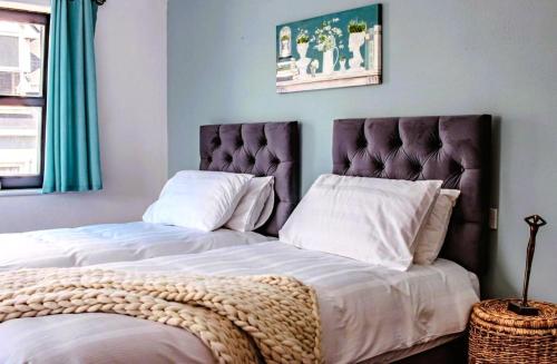 two beds with white sheets and a headboard in a bedroom at The Suite at O'Shea's in Killorglin