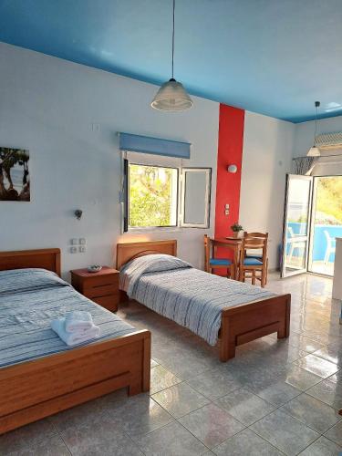 a bedroom with two beds and a table and chairs at Panorama Melina Apartments in Kastrí