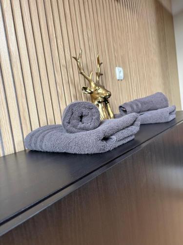 two towels on a table with a gold trophy at Au Charme de Durbuy in Durbuy