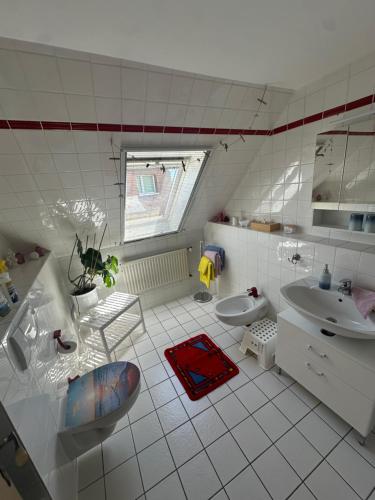 a white bathroom with a sink and a toilet at Ferienwohnung Wildblume in Fehmarn