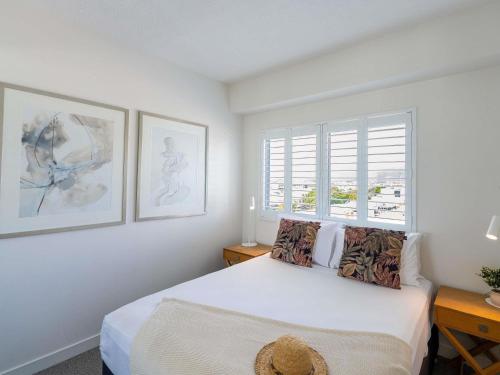a white bedroom with a bed and a window at BreakFree Royal Harbour in Cairns