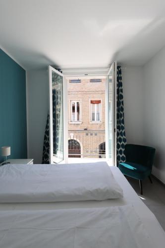 a bedroom with a white bed and a window at Domus Silvana Apartments in Ravenna