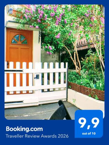 a white fence in front of a house with flowers at 2 Pièces cosy proche Metro in Asnières-sur-Seine