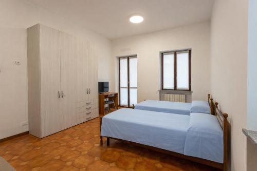 a bedroom with two beds and a white cabinet at Residenza Santa Rita in Novara