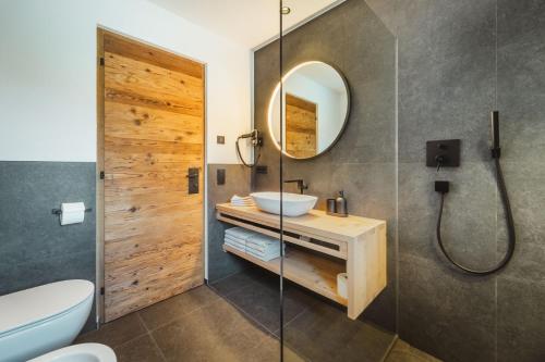 a bathroom with a sink and a mirror at Kuenzerhof Apartments in Braies