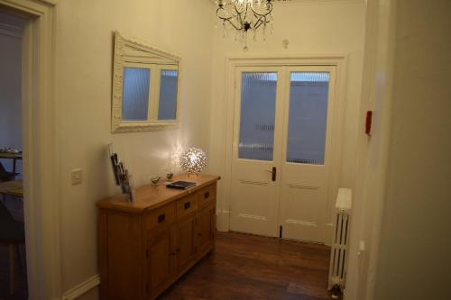 a room with a wooden dresser and a white door at Woodlyn Guest House in Gatehouse of Fleet