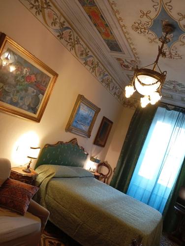 a bedroom with a bed and a chandelier at DIMORA della TORRE a due passi dal mare in Sestri Levante