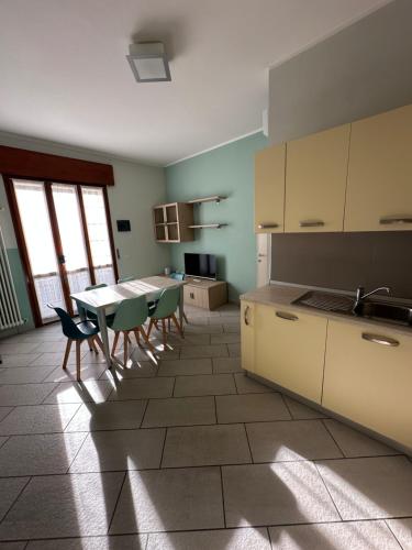 a kitchen with a table and chairs in a room at Apt Nettuno - Relax Privè - 3 Bedrooms - 2 Baths - AC - Parking - Wifi in Cervia