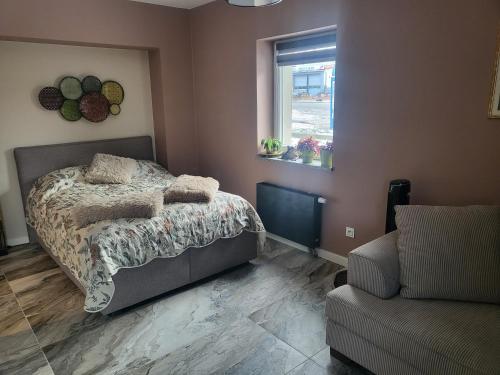 a bedroom with a bed and a couch and a window at Apartament Suzi dla dwojga in Kruszyn