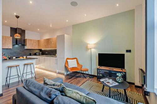 a living room with a couch and a kitchen at Modern Bright 3 Bedroom Apartment In Converted Brewery With Secure Undercover Gated Parking in Hull