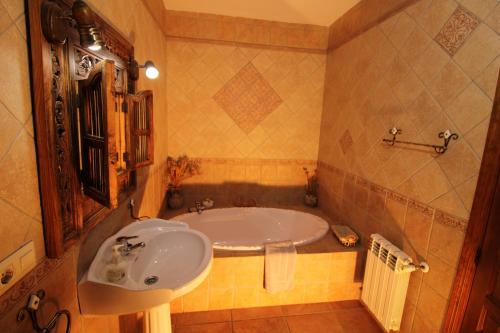 a bathroom with a tub and a sink at Loma la Parra in Valle de Abdalagís