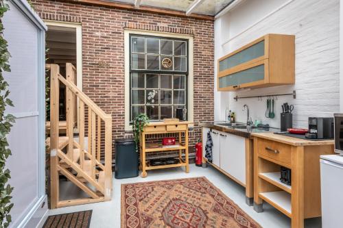a kitchen with a brick wall at Cozy two-room city center apartment with garden in Amersfoort