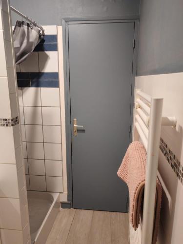 a door in a bathroom with a shower and a towel at Cabine de la plage 2 in Fécamp