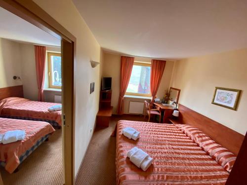 a hotel room with two beds and a table at Hotel-Restaurant Smilga in Kėdainiai
