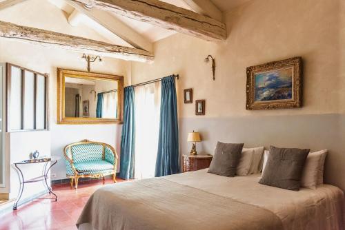 a bedroom with a bed and a chair and a window at Justin de Provence in Orange