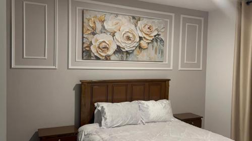 a bedroom with a bed with a painting on the wall at Upendo Apartment 2 Bedroom in Tilisi in Gatimu