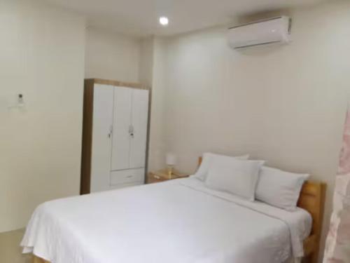 a white bed with white pillows and a mirror at Lukali Staycation in Tagbilaran City