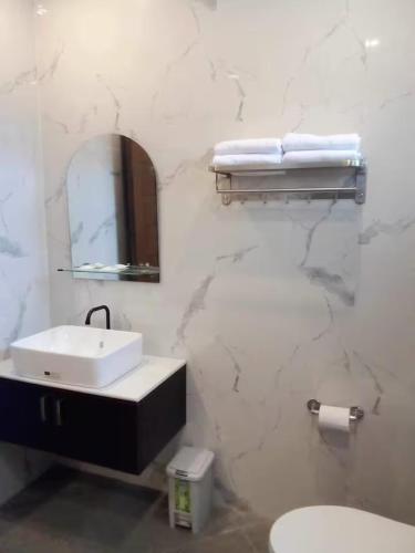 a bathroom with a sink and a mirror and a toilet at Lukali Staycation in Tagbilaran City
