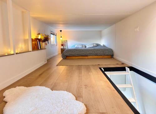 a bedroom with a bed in the corner of a room at Tiny House Cosy Climatisée in Saint-Sylvain-dʼAnjou