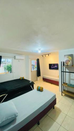 a bedroom with a large bed and a living room at Ap com ar próximo ao centro in Crateús