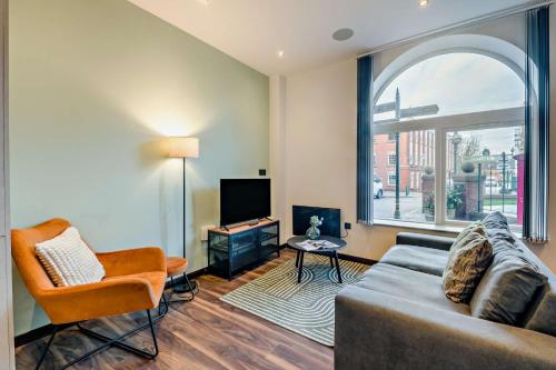 a living room with a couch and a tv at Modern Bright 3 Bedroom Apartment In Converted Brewery With Secure Undercover Gated Parking in Hull