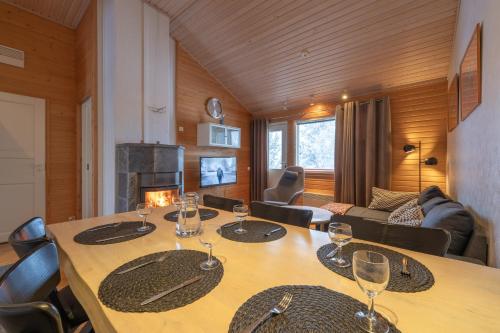 a dining room with a table with wine glasses on it at Kuukkeli Apartments Suite in Saariselka