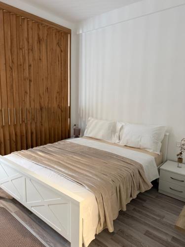 a bedroom with a large bed with a wooden wall at Golden LUX in Bar
