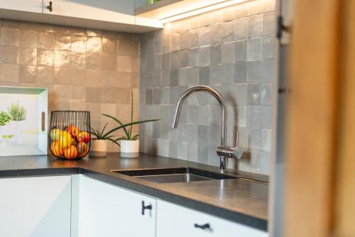 a kitchen with a sink and a counter top at Het Rustplekje in Alveringem