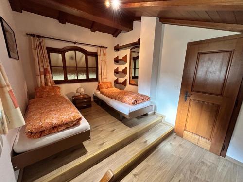 a bedroom with two beds and a wooden floor at Chalet Sunstar in Saas-Grund