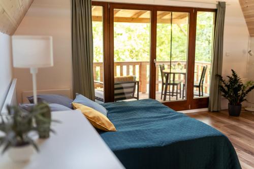 a bedroom with a bed and a balcony at Rigó Ház - Kisoroszi in Kisoroszi