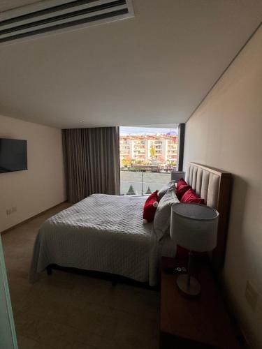 a bedroom with a bed with red pillows and a window at Nima bay in Puerto Vallarta