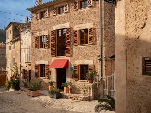 an old building with wooden shutters on a street at Marton Turisme de Interior in Valldemossa