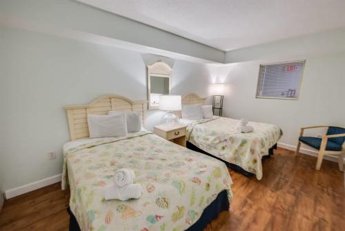 a hotel room with two beds and a teddy bear on them at Baywatch Renovated, Unobstructed Oceanfront Views in Myrtle Beach