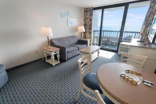 a living room with a couch and a table at Recently Renovated, Oceanfront View, Heated Pools! in Myrtle Beach