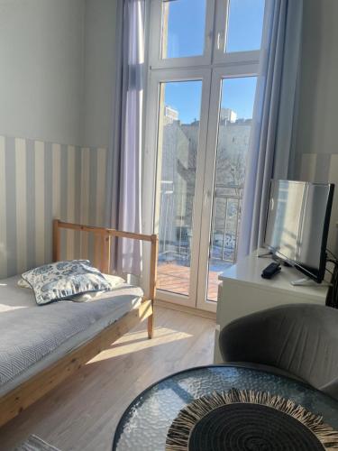 a bedroom with a bed and a large window at FRESCO PLUS -Filharmonia in Łódź