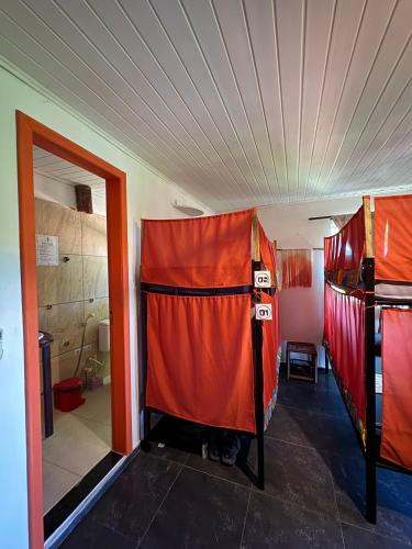 a room with two red bunk beds in it at Vila Pepouze Hostel in Morro de São Paulo