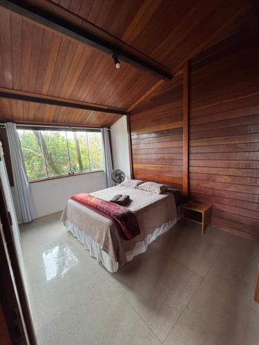 a bedroom with a bed in a room with wooden walls at CASA DA MATA - LAVRAS NOVAS in Lavras Novas