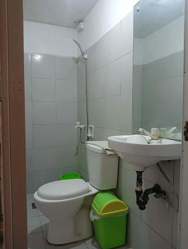 a bathroom with a toilet and a sink at Constrell Pension House in Tagbilaran City