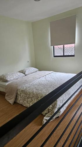 a bedroom with a large bed with a window at Abagta Kosan in Jakarta
