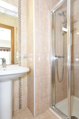 a bathroom with a shower and a sink at Mannin Lodge in Ballyconneely