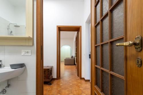 a hallway leading to a bathroom with a sink and a door at Residenza Santa Rita in Novara