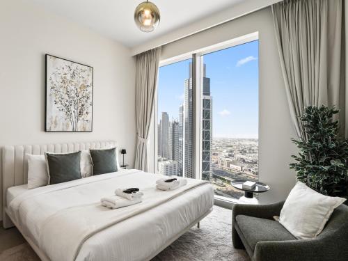 a bedroom with a bed and a large window at Exquisite 2BDR Retreat In Forte-33 in Dubai